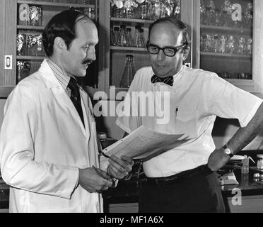 Two Centers for Disease Control (CDC) employees discussing test results in a laboratory, 1976. Image courtesy Centers for Disease Control. () Stock Photo