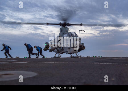 180421-N-VR594-0213 PACIFIC OCEAN (April 21, 2018) Sailors leave the landing area of the flight deck after applying chocks and chains on an AH-1Z Cobra assigned to Marine Light Attack Helicopter Squadron (HMLA) 267 aboard the Harpers Ferry-class amphibious dock landing ship USS Pearl Harbor (LSD 52). Pearl Harbor is currently underway off the coast of Southern California conducting routine training operations. (U.S. Navy photo by Mass Communication Specialist 3rd Class Kelsey J. Hockenberger/Released) Stock Photo