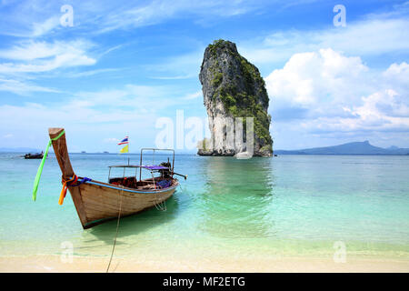 One Thai fishing boat tied up on the beach with a beautiful island in the background, Krabi, Thailand. Stock Photo