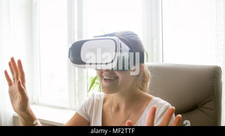 Closeup portrait of excited laughing woman wearing VR helmet at office Stock Photo