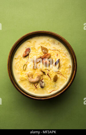 kheer or rice pudding is an Indian dessert in a brown terracotta bowl with dry fruits toppings Stock Photo