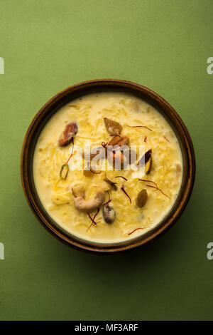 kheer or rice pudding is an Indian dessert in a brown terracotta bowl with dry fruits toppings Stock Photo