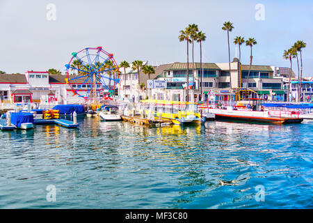 NEWPORT BEACH, CA, USA - MAR 29, 2018: Popular pier at Balboa peninsula in Southern California with ferris wheel, tourist shops, restaurants and boats Stock Photo