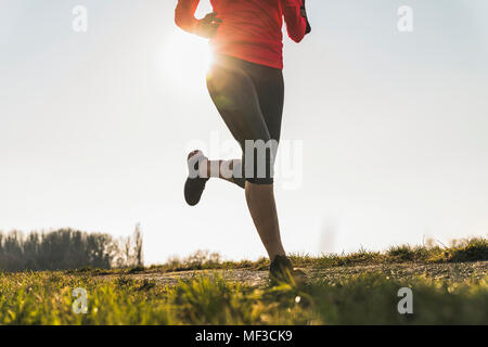 Low section of woman running on rural path Stock Photo
