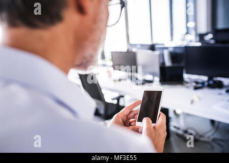 Close-upof businessman in office using smartphone Stock Photo