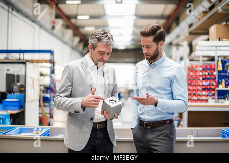 Businessmen during meeting with a product in production hall Stock Photo
