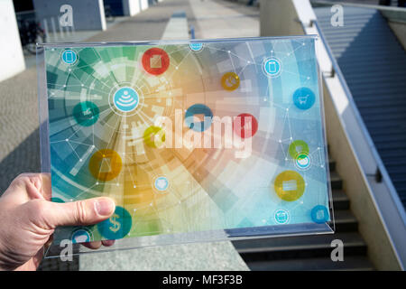 Hand holding futuristic device with digital icons Stock Photo