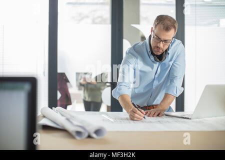 Man making notes on plan in office Stock Photo