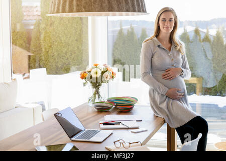 Portrait of smiling pregnant woman working from home Stock Photo