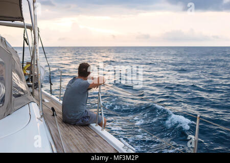 Indonesia, Lombok island, man sitting on deck of a sailing boat