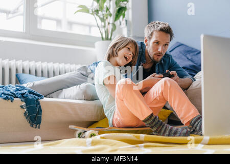 Father and son playing video game together at home Stock Photo