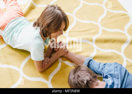 Son defeating father in arm wrestling Stock Photo