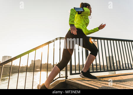 Young woman running up stairs at a river Stock Photo