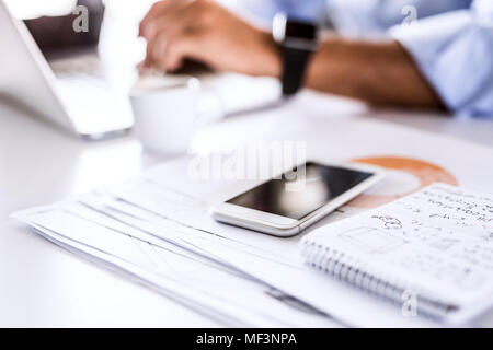 Smartphone and notepad on desk in office Stock Photo