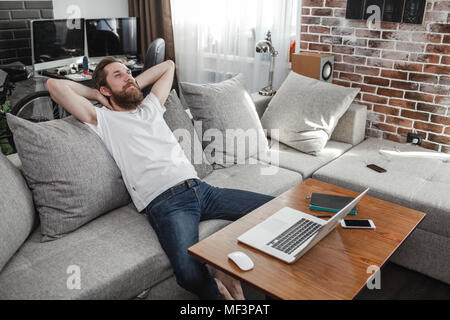 Smiling man relaxing on the couch at home Stock Photo