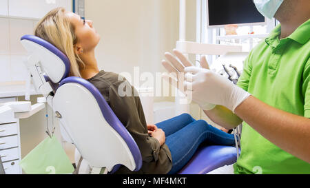 Closeup image of male dentist putting on protective latex gloves Stock Photo