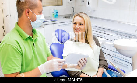 Portrait of beautiful smiling woman sitting in dentist office and talking to dentist Stock Photo
