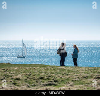 People walking at Sound, view toward sea with distant sailing boat Stock Photo