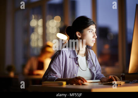 Young businesswoman working on the computer at late night shift Stock Photo