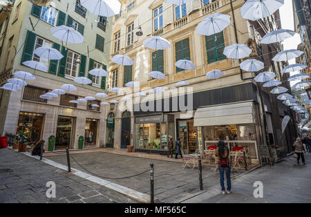 GENOA, ITALY, APRIL 16, 2018 - White umbrellas in the sky above the streets in the center of Genoa, Italy. Stock Photo