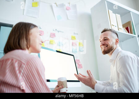 Business coworkers sitting in front of the computer and discussing presentation Stock Photo