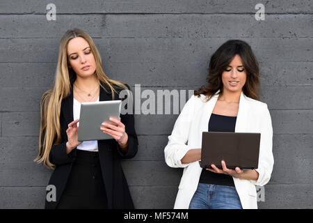 Two businesswomen using tablet and laptop Stock Photo