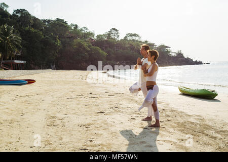 Thailand, Koh Phangan, couple doing yoga on a beach Stock Photo