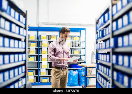 Businessman using tablet in storage Stock Photo