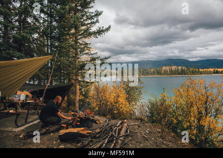 Canada, British Columbia, man making camp fire at Boya Lake Stock Photo