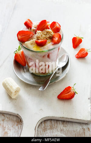 Strawberry banana parfait with oat flakes and yogurt in glass Stock Photo