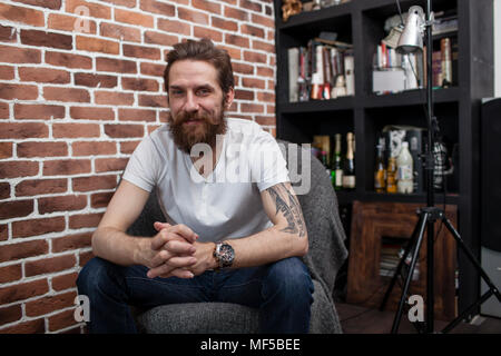 Portrait of smiling man sitting on armchair at home Stock Photo
