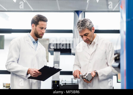 Engineers measuring product Stock Photo