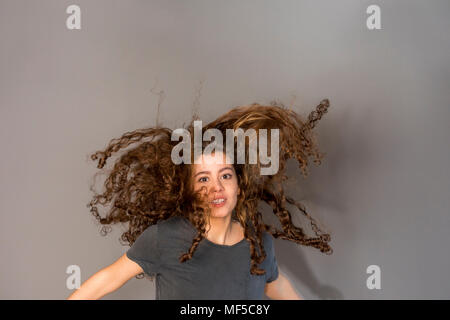 Pretty teenage girl with curly hair, jumping Stock Photo