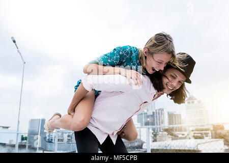 Young affectionate couple having fun together on rooftop Stock Photo