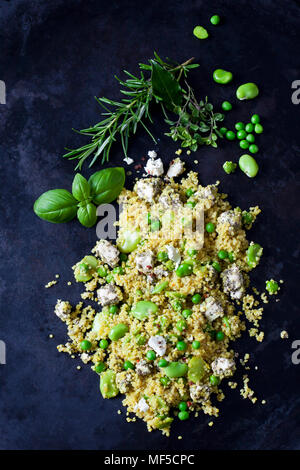 Quinoa salad with broad beans, peas and feta on dark metal Stock Photo