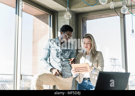 Two colleagues with tablet discussing in office Stock Photo