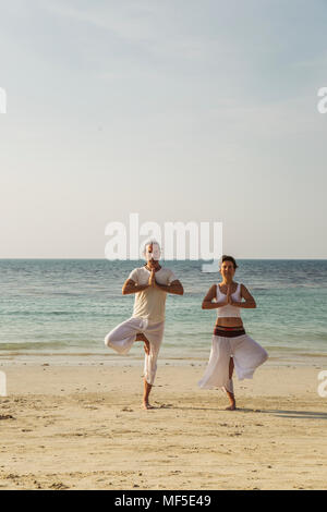 Thailand, Koh Phangan, couple doing yoga on a beach Stock Photo