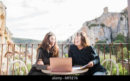 Spain, Alquezar, two women working together with laptop on terrace Stock Photo