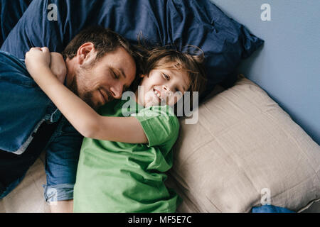 Father and son cuddling at home Stock Photo