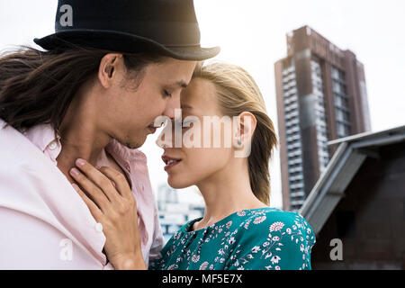 Young affectionate couple kissing on rooftop Stock Photo