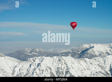 Austria, Salzkammergut, Hot air balloon over alpine landscape in winter Stock Photo