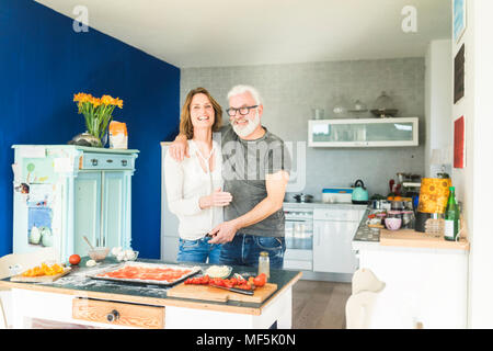 Happy mature couple embracing in kitchen at home Stock Photo
