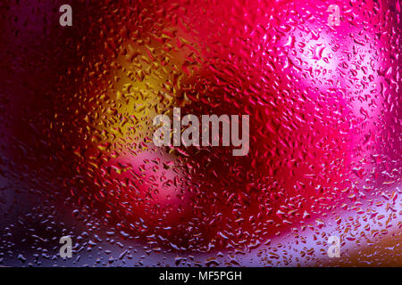 Pink lady apple behind wet glass, obscured by water droplets. Interesting screen saver design. Abstract / background. Stock Photo