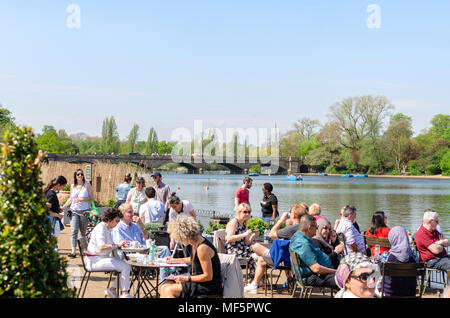 Crowds of people enjoying the spring sunshine at by the Serpentine at Hyde Park, London Stock Photo
