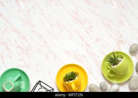 Flat lay of creative colored marble desk with green cup, stones and succulents background Stock Photo