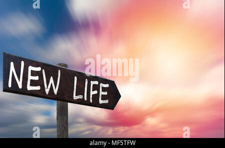 New life motivational phrase on wooden sign against colorful sunny sky and speedy clouds. Copy space. Change concept. Stock Photo