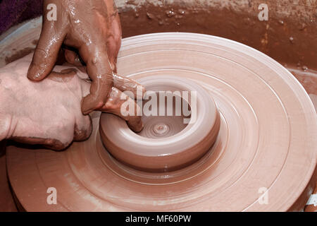 potter working clay on a spinning wheel in the uk Stock Photo