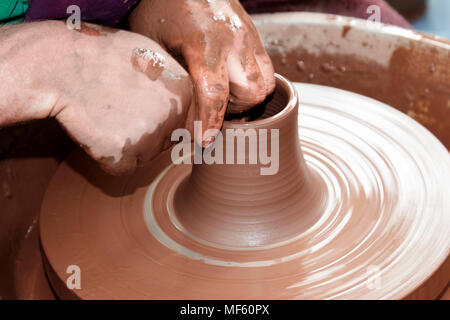 potter working clay on a spinning wheel in the uk Stock Photo