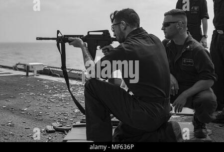 180418-N-DO281-0256 MEDITERRANEAN SEA (April 18, 2018) Interior Communications Electrician 3rd Class Austyn Hanif, left, fires a M-16 rifle and Gunner's Mate 2nd Class Billy Riley, right, stands line coach during a live-fire exercise aboard the guided-missile cruiser USS Monterey (CG 61), April 18, 2018. Monterey, home-ported in Norfolk, Virginia, is conducting operations in the U.S. 6th Fleet area of operations in support of U.S. national security interest in Europe. (U.S. Navy photo by Mass Communication Specialist Seaman Trey Fowler). () Stock Photo