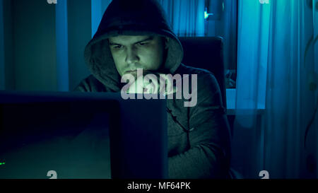 Portrait of young concentrated man working on laptop at night Stock Photo